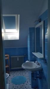 La salle de bains bleue est pourvue d'un lavabo et d'un miroir. dans l'établissement Dachgeschoss35, à Witten