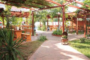 a garden with a wooden pergola and a patio at Alba Family Club Hotel in Primorsko