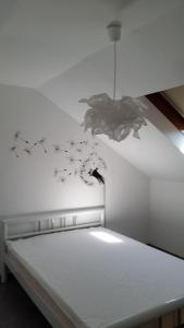 un banc blanc avec des oiseaux et des papillons sur le mur dans l'établissement Dachgeschoss35, à Witten