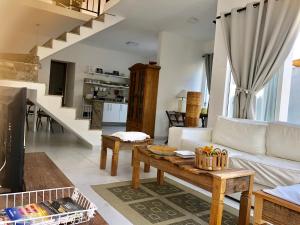 a living room with a white couch and a table at Villa Vitoria in Cabo Frio