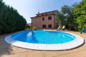 a large swimming pool in front of a house at Apartments Radojka in Novigrad Istria
