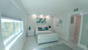 a white bedroom with a bed and a window at Pompano Beach Hidden Gem in Pompano Beach +32 photos