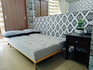 a bed in a room with a table and a bed sidx sidx at Condo Unit walking distance to Manila Airport (NAIA Terminal 3) in Manila