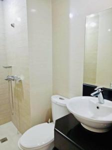 a bathroom with a sink and a toilet and a mirror at Condo Unit walking distance to Manila Airport (NAIA Terminal 3) in Manila