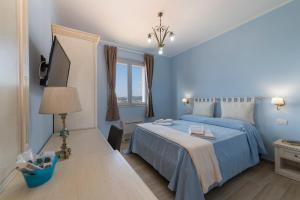 Dormitorio azul con cama y ventana en Podere Abbazia b&b, en Sinalunga