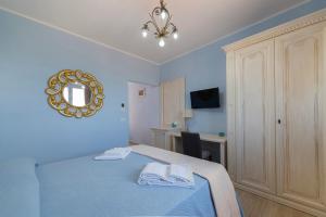 Dormitorio azul con cama y espejo en Podere Abbazia b&b en Sinalunga