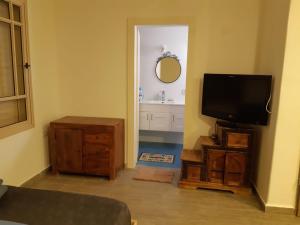 uma sala de estar com uma televisão de ecrã plano e uma cómoda em The Birdwatchers Nest em Beʼer Ora