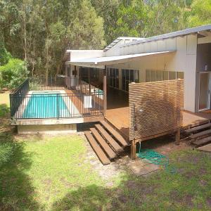 a house with a deck and a swimming pool at Sandyfeet House in Rainbow Beach