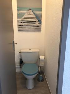 a bathroom with a toilet with a picture of a pier at Appartement cocooning plage des lecques in Saint-Cyr-sur-Mer