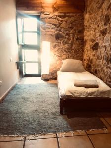 ラバナル・デル・カミーノにあるThe Stone Boat Guesthouse for Pilgrimsの石壁のベッドルーム1室(ベッド1台付)