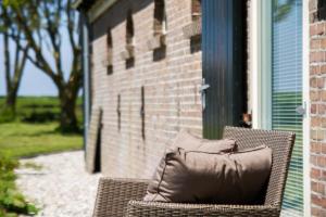 a pillow sitting on a wicker chair on a porch at Traphoeve in Schagen