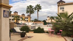 a balcony of a house with chairs and palm trees at Aalia villa in Villacosta