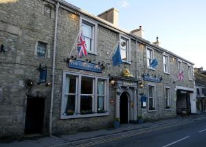 a building with flags on it on a street at The Golden Lion at Settle in Settle