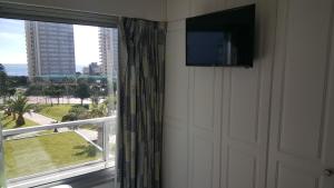 a flat screen tv on a wall next to a window at Torre Wilson - Complejo Lincoln Center in Punta del Este
