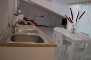 a kitchen with a sink and a table with a counter at Duchessa House in Castellammare del Golfo