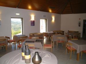 um restaurante com mesas e cadeiras e uma sala com vista em INATEL Linhares da Beira Hotel Rural em Linhares
