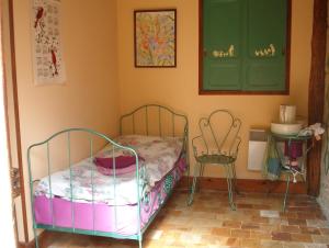 a small bedroom with a bed and a chair at Coté Jardin in Villiers-sur-Loir