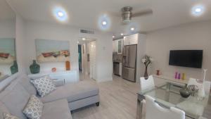 a living room with a couch and a tv at Pompano Beach Hidden Gem in Pompano Beach