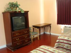 a living room with a tv and a desk at Travel Inn in Los Angeles
