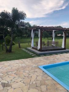 a gazebo with a bench and a swimming pool at Tureck Garten Hotel in Corupá