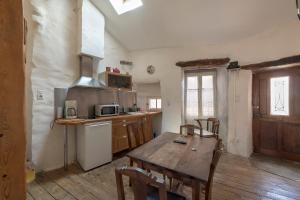 Il comprend une cuisine avec une table en bois et du parquet. dans l'établissement La maison d'Angèle, à Sainte-Eulalie-de-Cernon