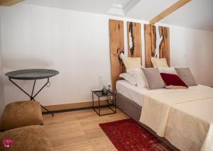 ギマランイスにあるL'atelier Apartments (Fotografia)のベッドルーム1室(木製ヘッドボードとテーブル付きのベッド1台付)