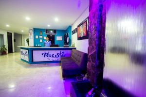 a bar with a purple couch in a room at Blue Star Hotel in Melgar