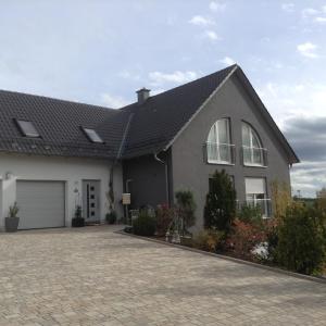 ein Haus mit einem grauen Dach und einer Auffahrt in der Unterkunft Ferienwohnung Christine in Tanzfleck