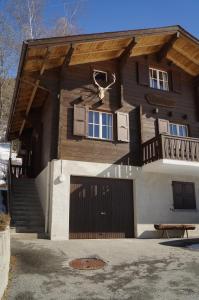 a house with a porch and a gate in front of it at Chalet Berken in Ernen