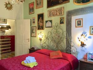 Un dormitorio con una cama roja con toallas. en La Stagione dell'Arte, en Camaiore