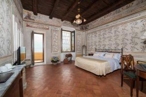 a bedroom with a bed and a television in it at Palazzo Suriano Heritage Hotel in Vietri sul Mare +89 photos