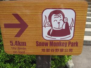 a sign for a show monkey park with a monkey on it at Maruka Ryokan in Yamanouchi