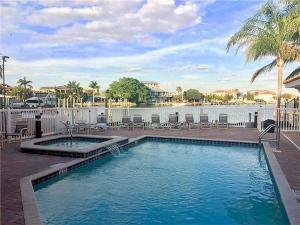 a swimming pool with chairs and a body of water at Luxury 5 Star Condominium Water Front 3 Beds 2 Bath Pool Hot-Tub Beach And City Views in Clearwater Beach