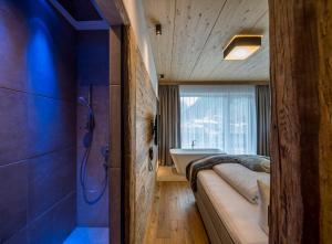 een badkamer met een bed en een bad in een kamer bij Post Hotel Paznaun in See