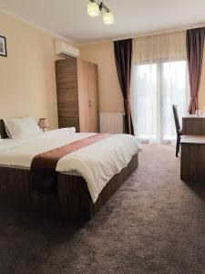 a hotel room with a large bed and a desk at Villa Lotus in Deva