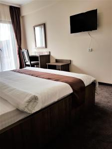 a hotel room with a bed and a flat screen tv at Villa Lotus in Deva +66 photos