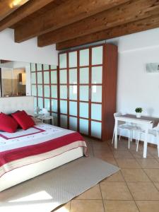 Schlafzimmer mit einem Bett mit roten Kissen und einem Tisch in der Unterkunft Rovelli Room in Bergamo