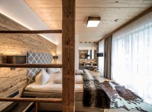 a bedroom with a bed in a room with wooden walls at Post Hotel Paznaun in See