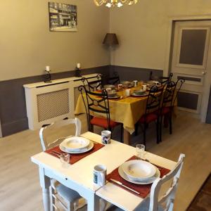 comedor con mesa blanca y sillas en Le Puy Robin, en La Souterraine
