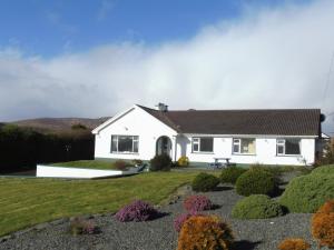 uma casa branca com um jardim em frente em Island View House em Castletownbere