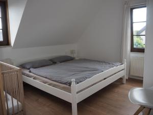 a white bed in a white room with two windows at Ferienhaus Mundan 2 in Burhave