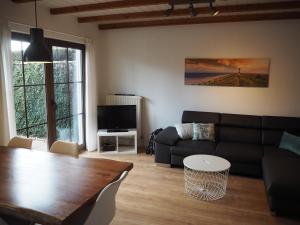 ein Wohnzimmer mit einem Sofa und einem Tisch in der Unterkunft Ferienhaus Mundan 2 in Burhave