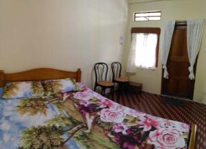 a bedroom with a bed with a floral comforter at Goshen homestay in Cherrapunji