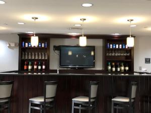 a bar with chairs and a flat screen tv at Best Western Plus Goodman Inn & Suites in Horn Lake
