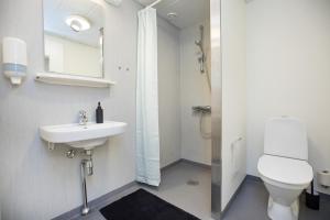 a bathroom with a sink and a toilet and a mirror at OnlySleep Trafikcenter in Slagelse