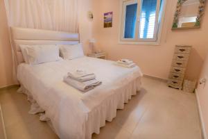 a bedroom with a white bed with towels on it at Mariliz in Larnaka