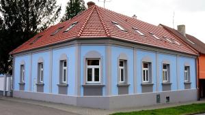 ミクロフにあるAlegria Natur Apartmentsの赤屋根の青い建物