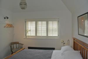 ホープ・コーブにあるPort, Old Colonial Houseのベッドルーム1室(ベッド2台、ブラインド付きの窓付)が備わります。