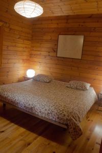 1 dormitorio con 1 cama en una pared de madera en Beewood, en Fiais