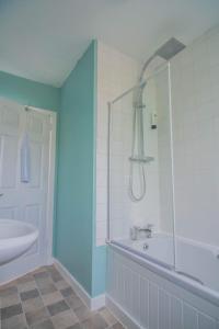 a bathroom with a shower and a tub and a sink at Wells Street Cottages No 26 By The River Ness in Inverness